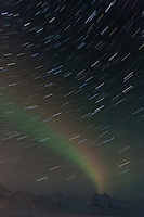 Star trails and faint aurora borealis, (northern lights) over the Brooks range mountains, in the direction of the Arctic National Wildlife Refuge.