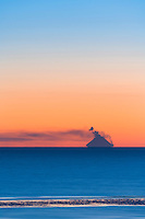 Mt. Augustine active volcano, March 2006, view from Kachemak Bay, Homer, Alaska, across the Cook Inelt. Approximately 75 miles from the Volcano, which sits as an island off the coast of the Alaska Peninsula. Atmospheric conditions create the optical illusion of a vanishing edges at the base where the volcano meets the water.