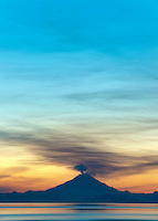 Plume of gas and vapor vent from the summit of Mt. Redoubt volcano (10,191 ft), of the Chigmit mountains, Aleutian range. View across Cook Inlet approximately 50 miles, at sunset, southcentral, Alaska.