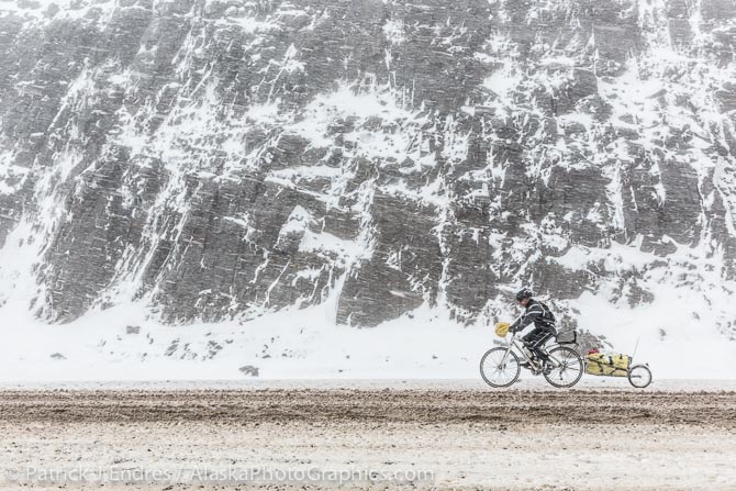 Bicycle rider in Atigun Pass during a snowstorm. June 12, 2014.